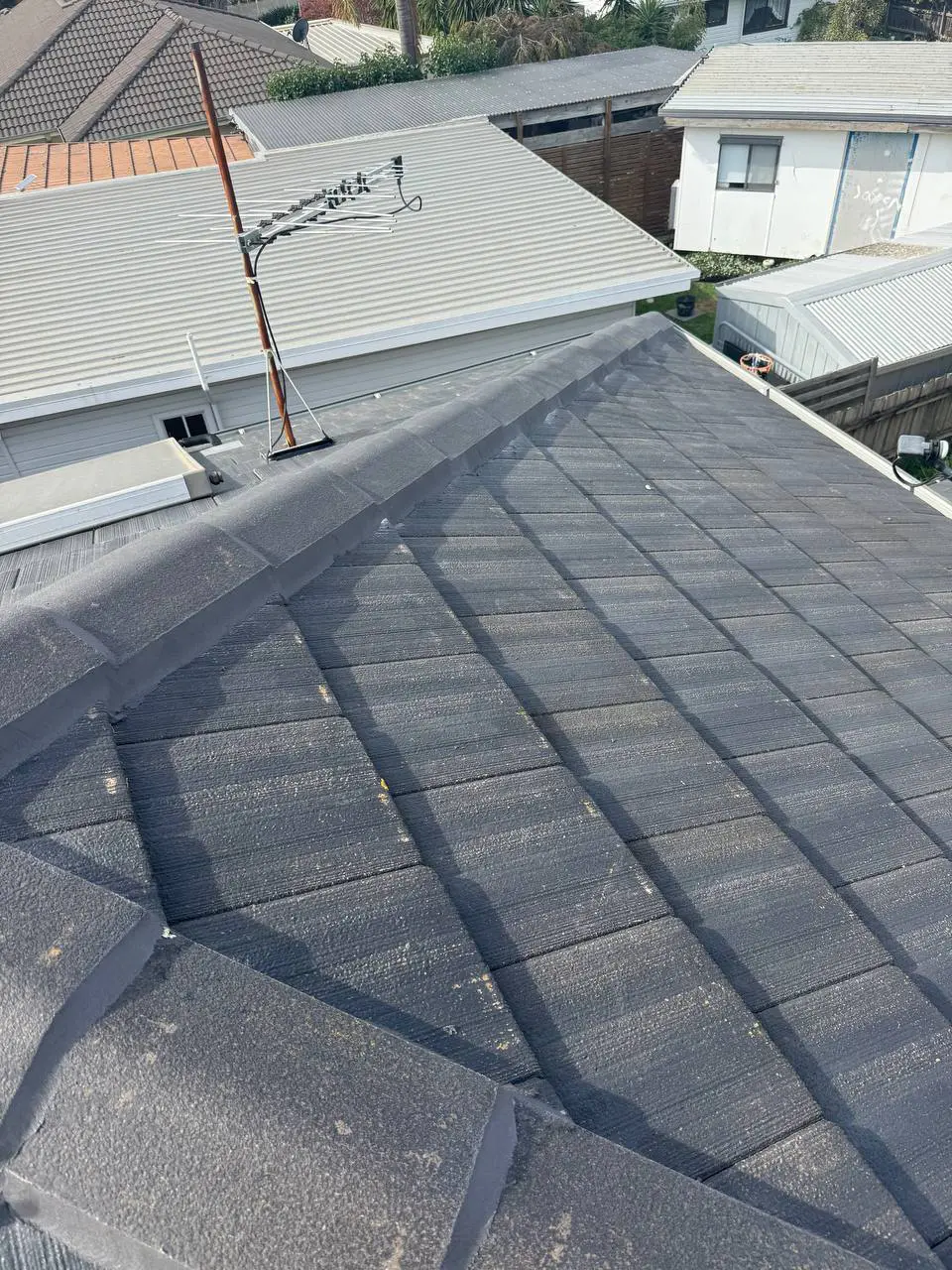 Weathered tile roof with cracked ridge pointing and moss, before repair — project 1