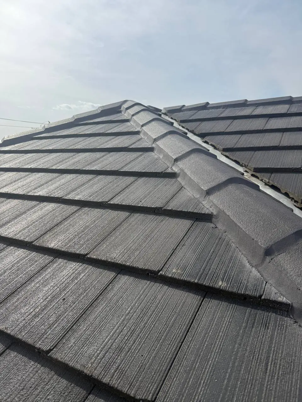 Weathered tile roof with cracked ridge pointing and moss, before repair — project 3